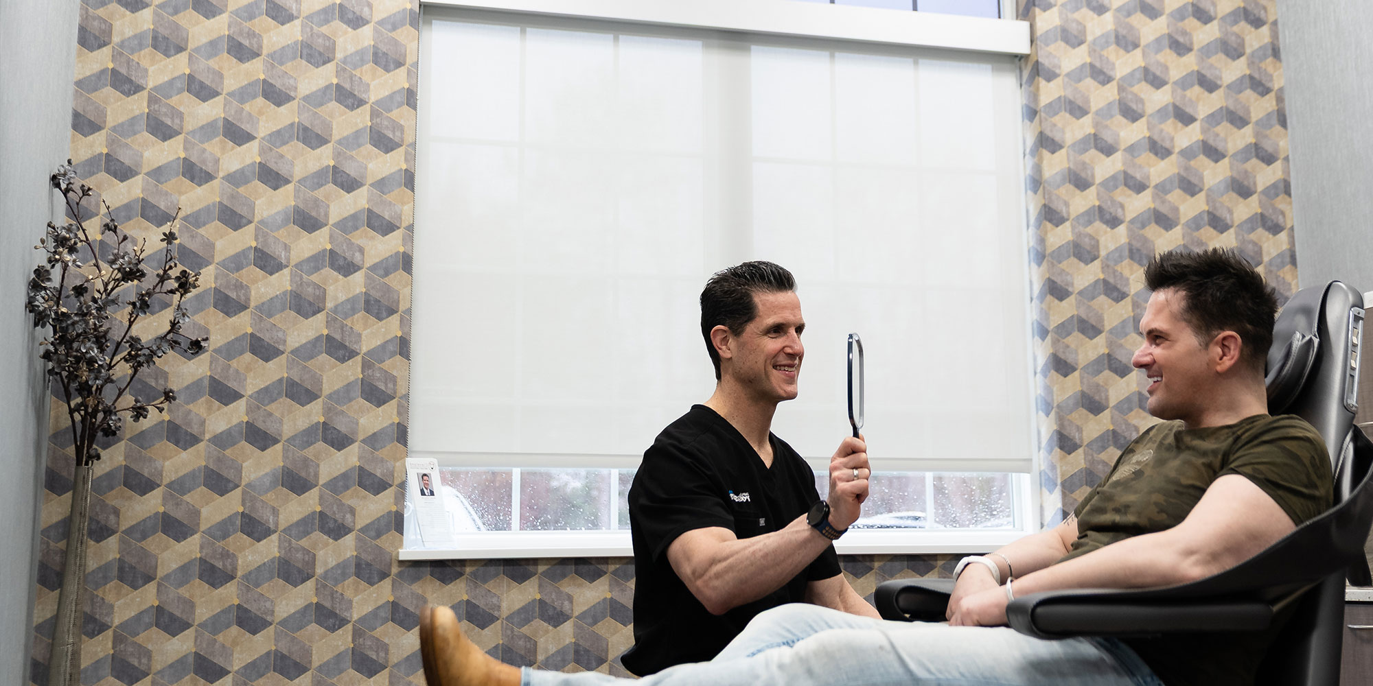 Doctor showing patient their new smile holding up a mirror