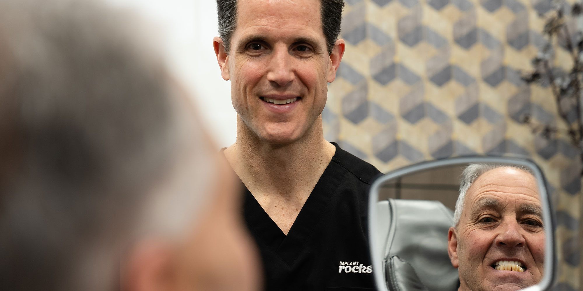 doctor holding up mirror for patient