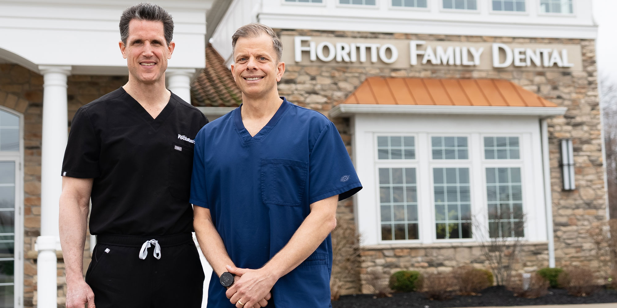 doctors standing outside their dental office