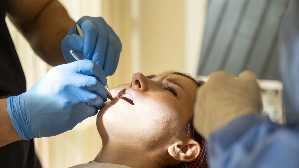 Close-up animated image depicting the various stages of the front tooth implant process, including initial consultation, implant placement, healing, and final crown restoration. No text on the image.